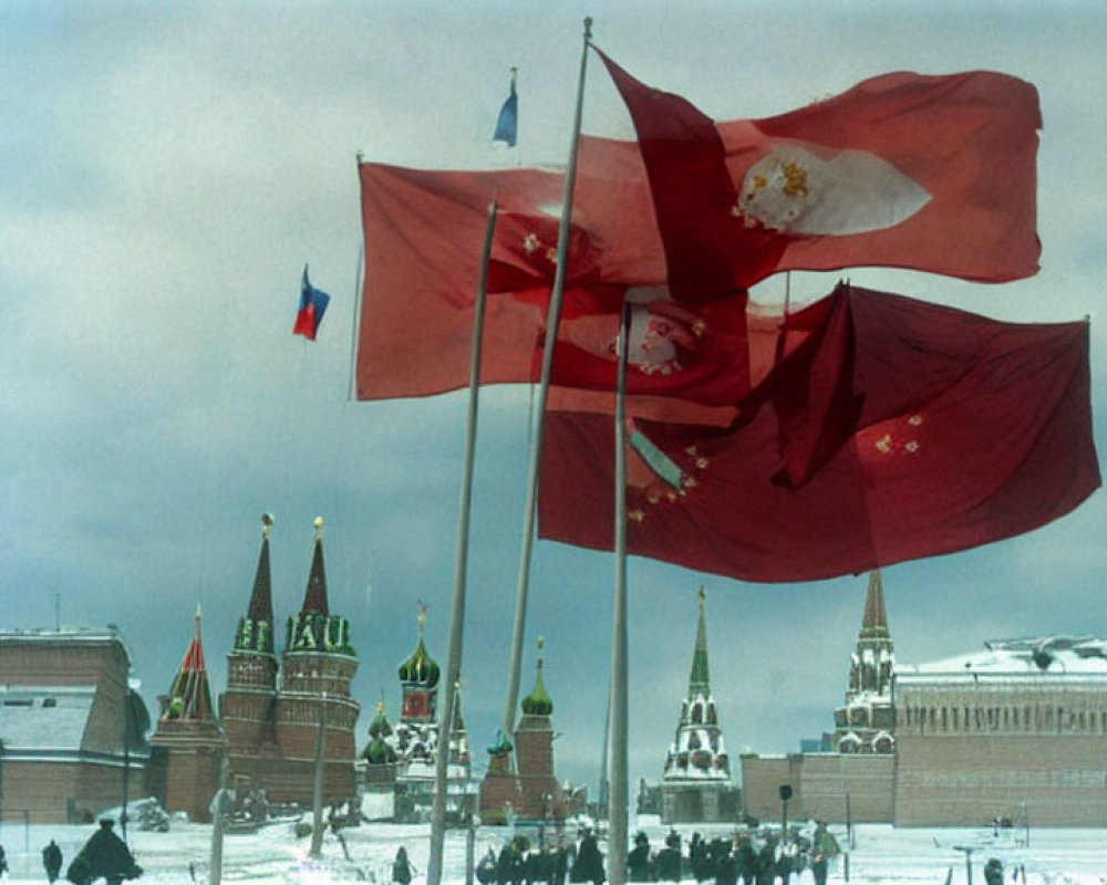 Three flags flying in front of Kremlin and snow-covered ground