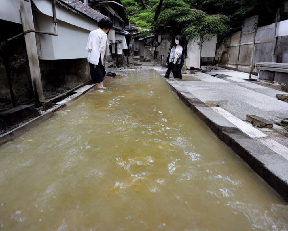 Canal with cloudy water and individuals in traditional stone-lined pathways