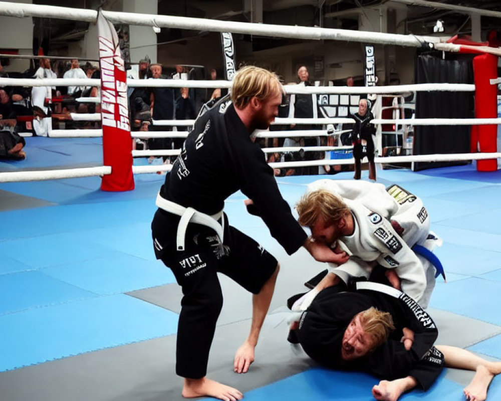 Brazilian Jiu-Jitsu practitioners in black and white gis in a dojo with spectators