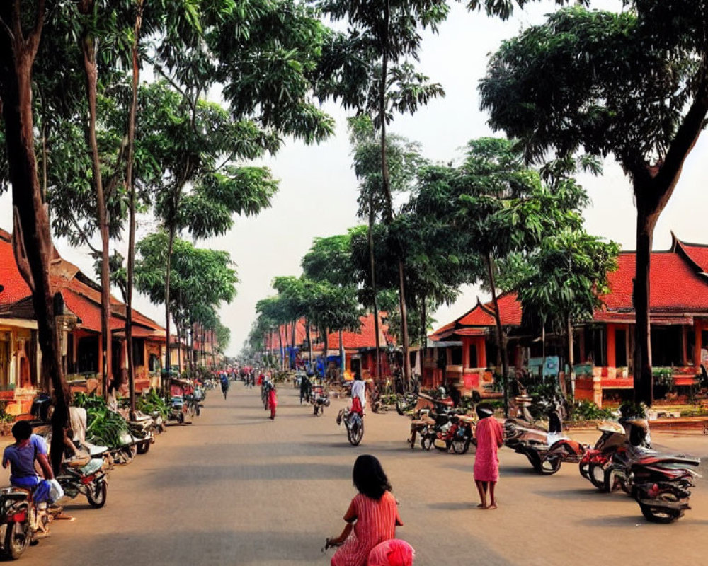 Urban scene with tree-lined street, motorbikes, pedestrians, and red-roofed buildings under