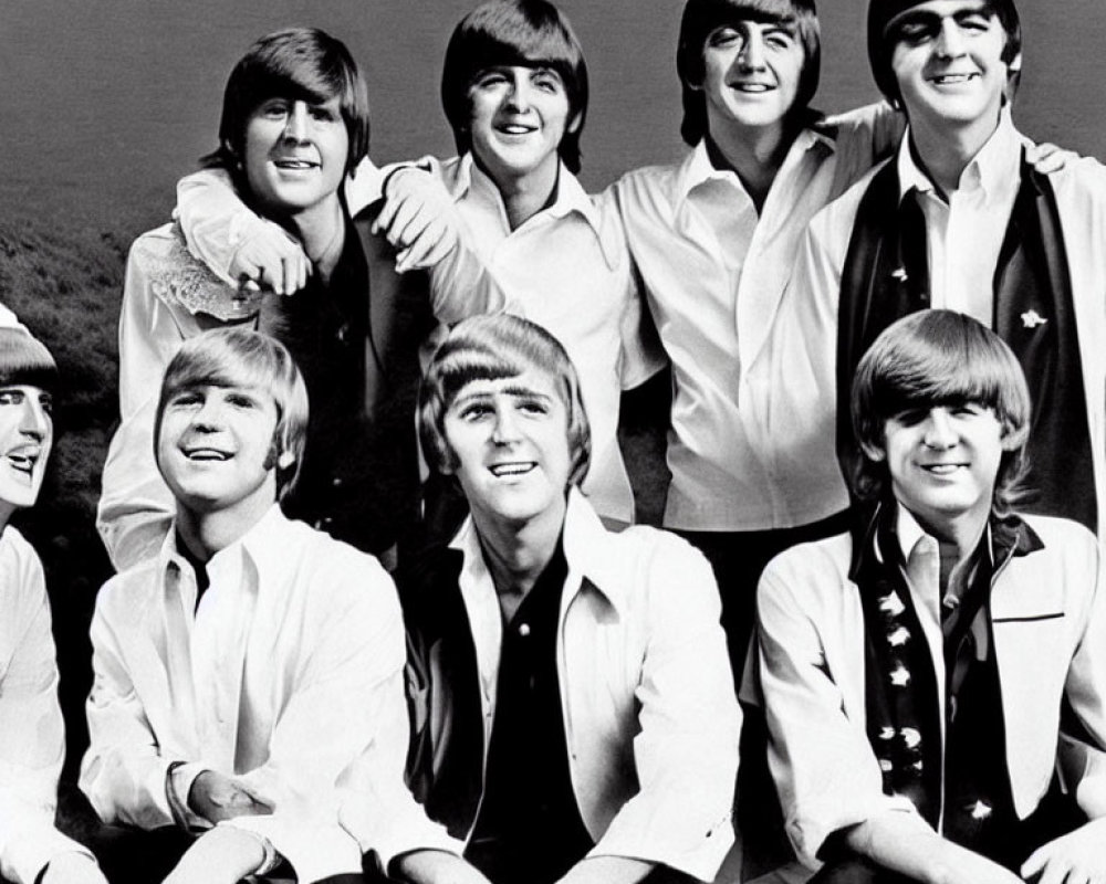 Group of seven young men in black and white photo with similar hairstyles and white shirts