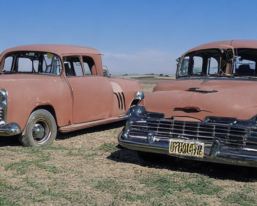 Vintage Rust-Colored Cars Parked on Grassy Field Under Clear Blue Sky