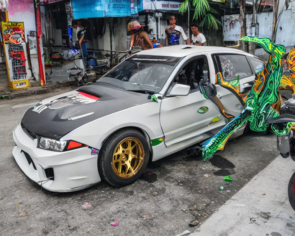 Custom Wide Body Sedan with Gold Rims and Graffiti Decals on City Street