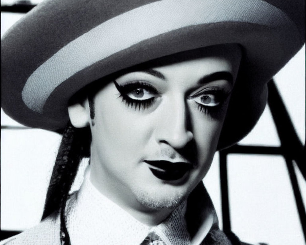 Monochrome portrait of person with dark lipstick and large brimmed hat