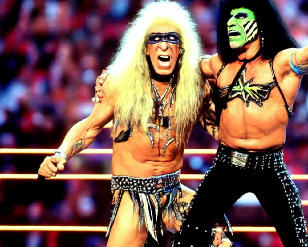 Colorful face paint and flamboyant costumes: Professional wrestlers posing in a wrestling ring.