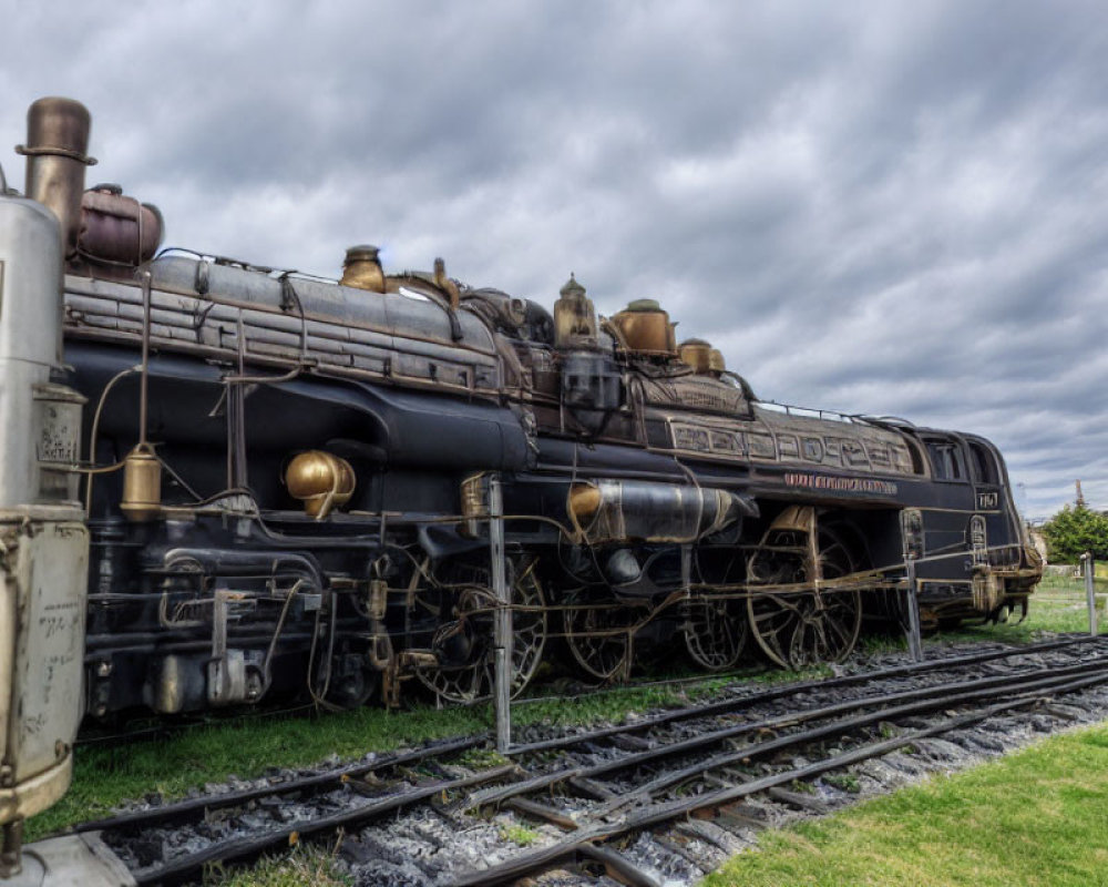 Vintage Steam Locomotive on Tracks with Cloudy Sky Showing Intricate Design and Metallic Textures