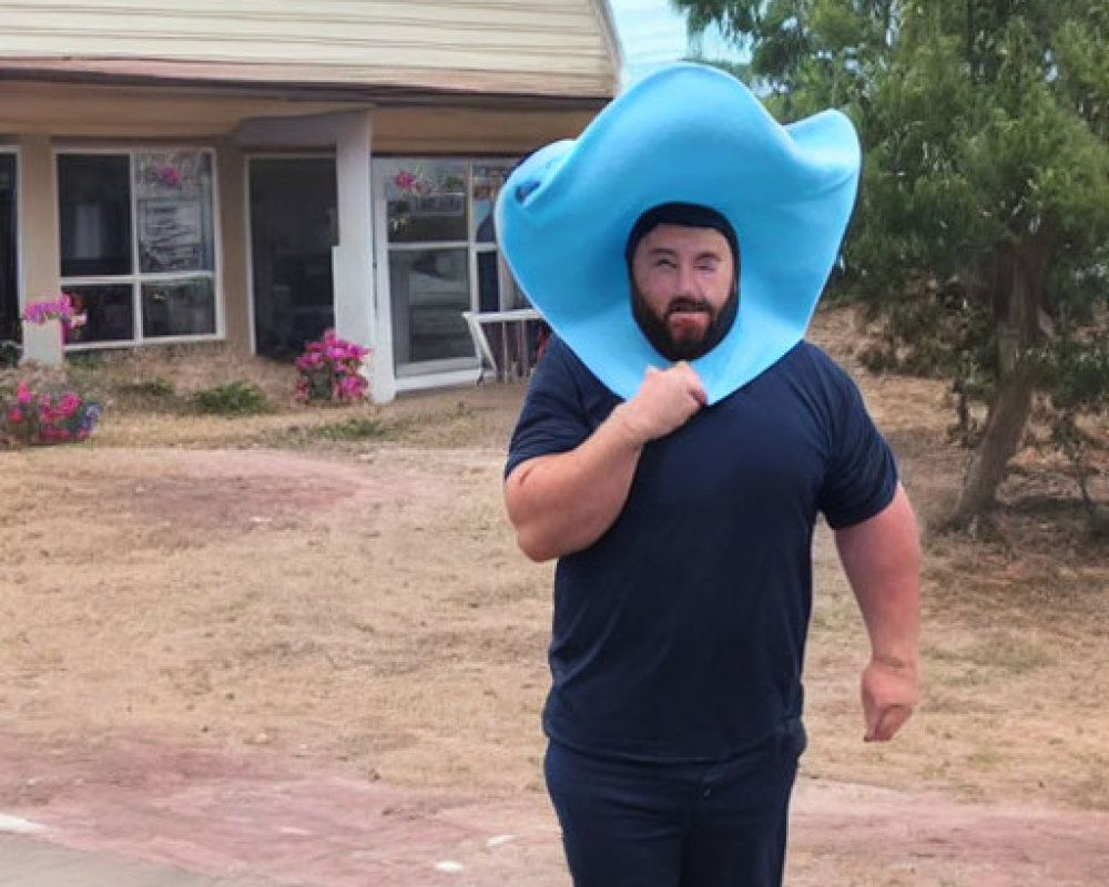 Bearded man in blue outfit and floppy hat walking outdoors