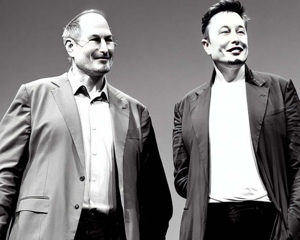 Two men in business attire smiling under dramatic spotlight