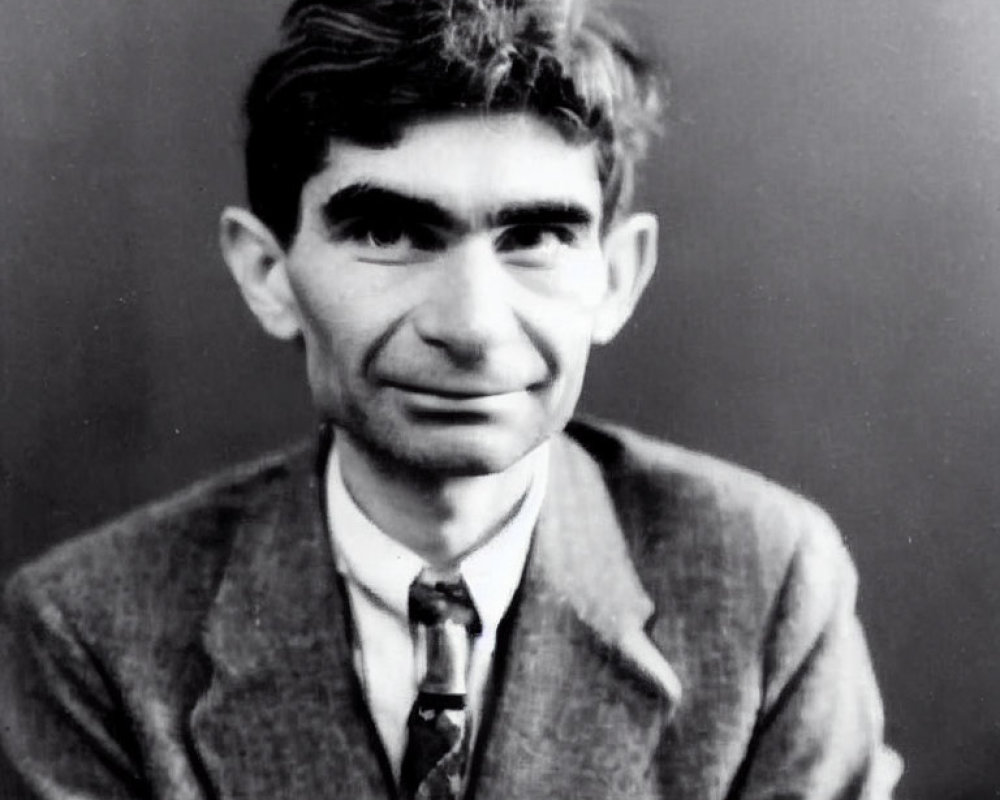 Monochrome portrait of man with dark hair and tie, direct gaze