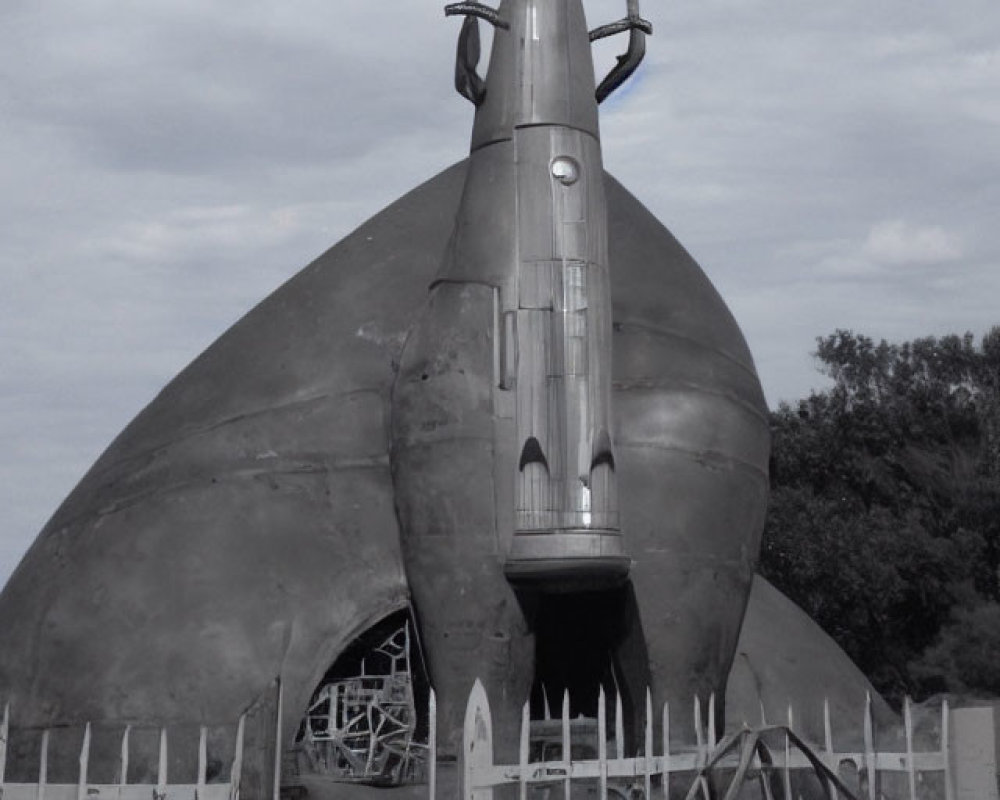 Monochrome photo of rocket-shaped structure on damaged dome under cloudy sky