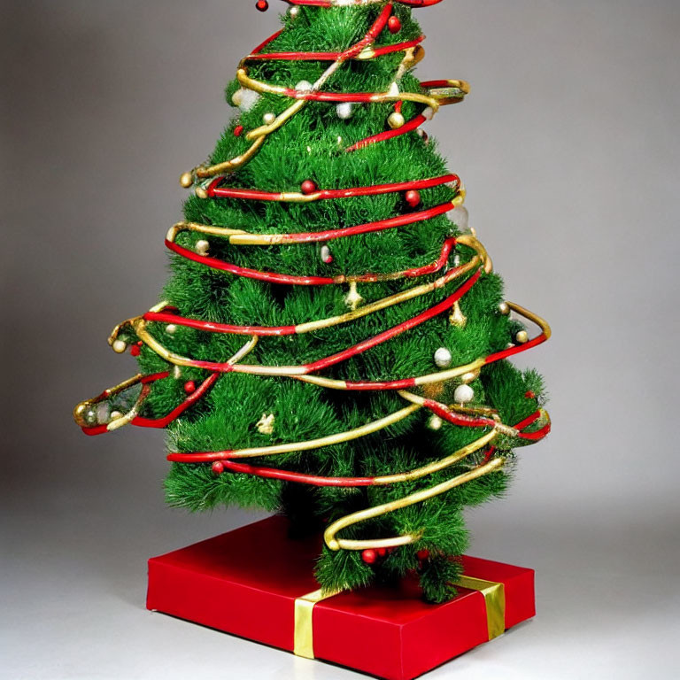 Artificial Christmas tree with red and gold garlands on red base