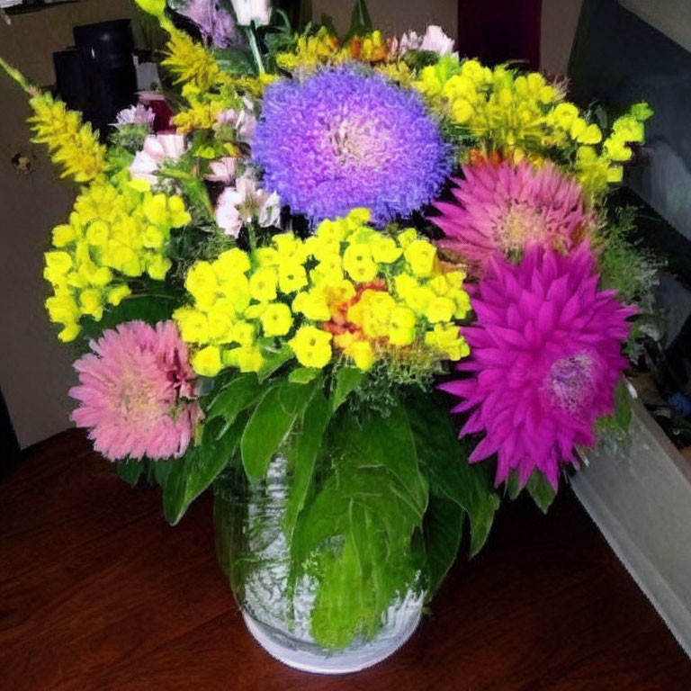 Colorful Pink, Purple, and Yellow Floral Arrangement in Glass Vase