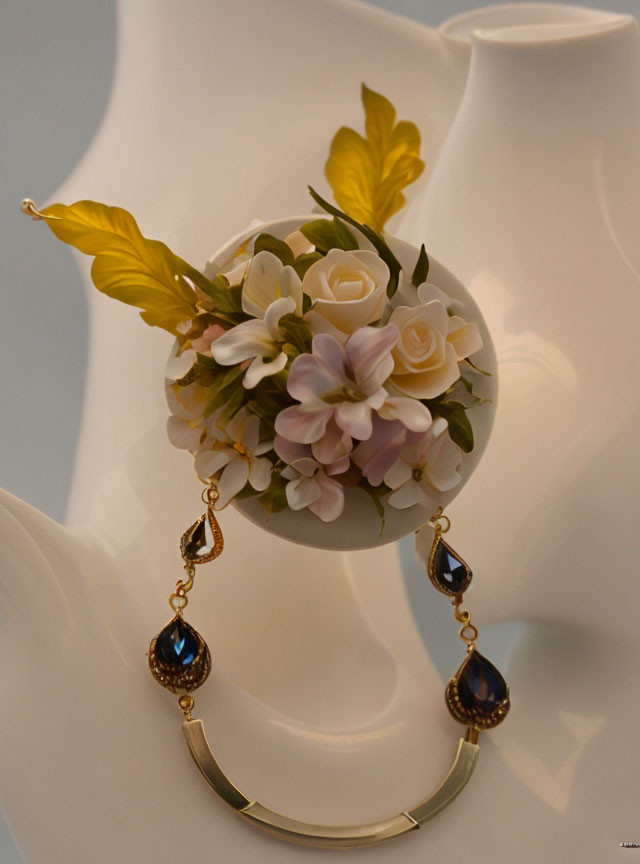 Mannequin bust with spherical floral arrangement and elegant blue gemstone earrings