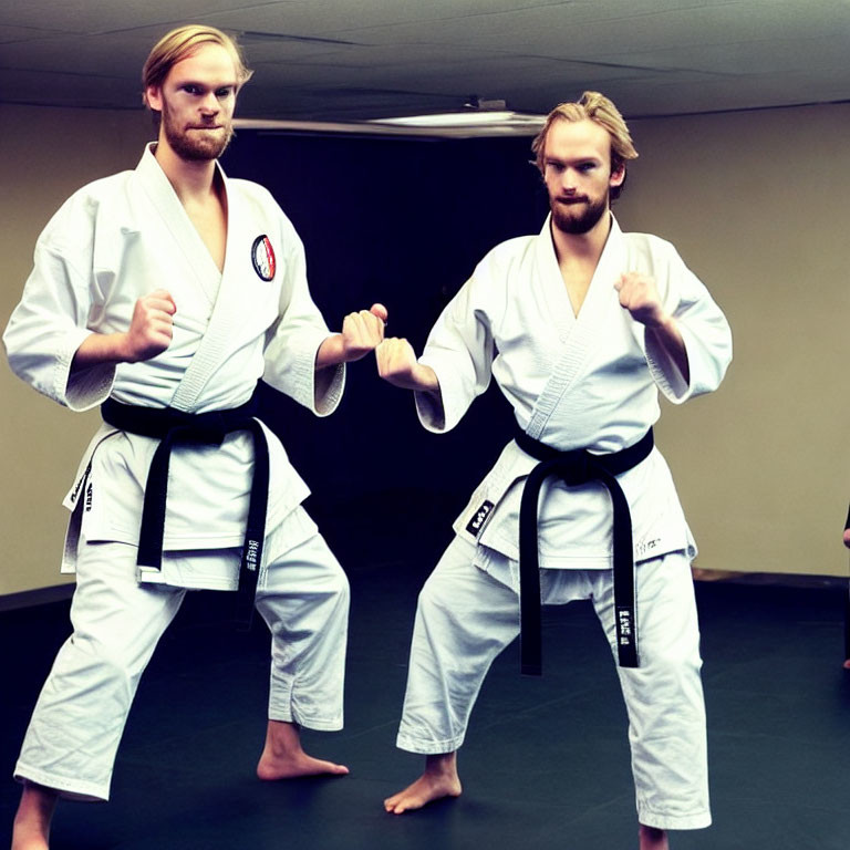 Martial Artists in White Gi and Black Belts Practicing in Dojo