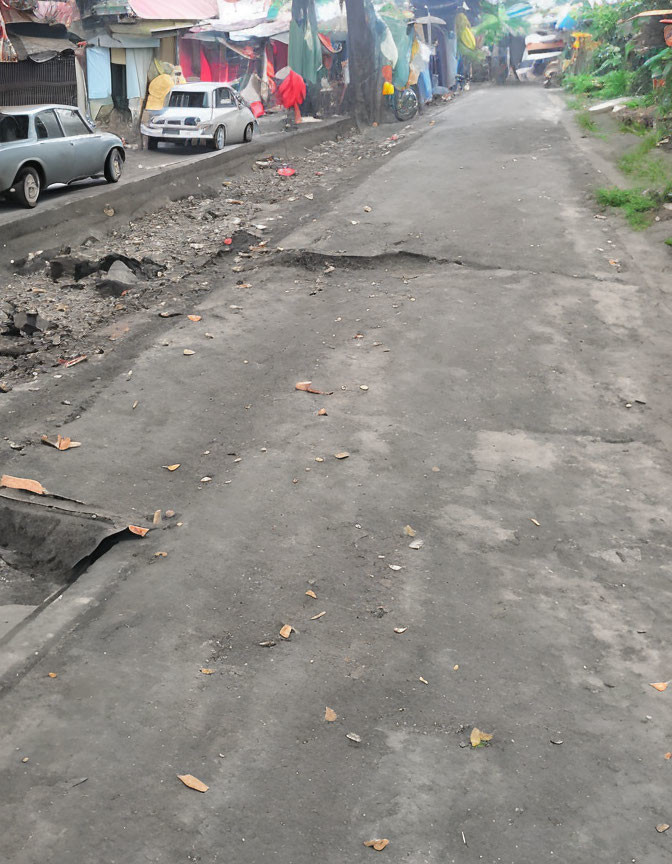 Residential area road with potholes, parked cars, and colorful flags