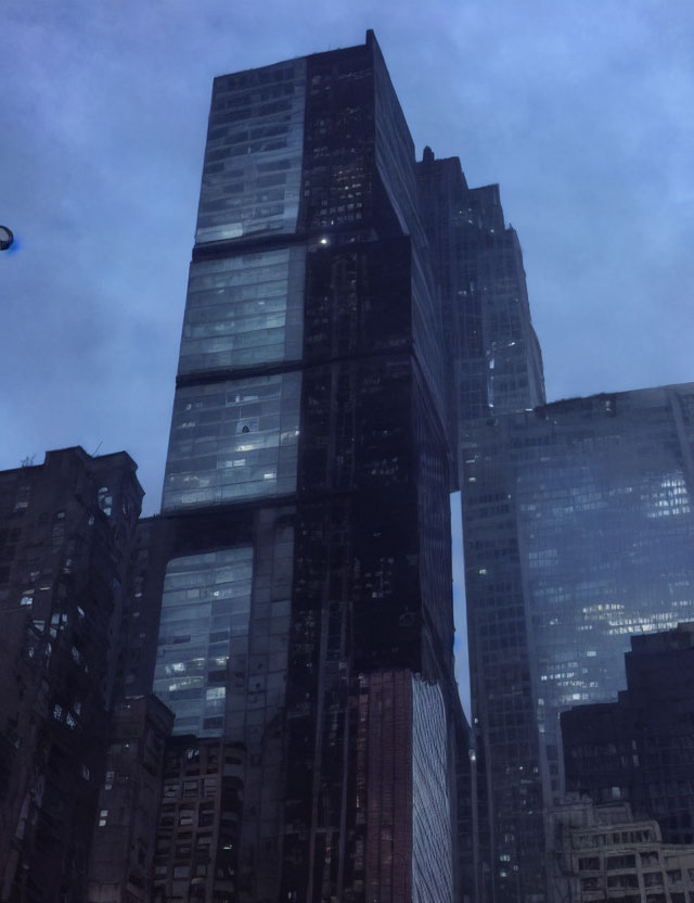 Modern skyscraper in urban cityscape at dusk