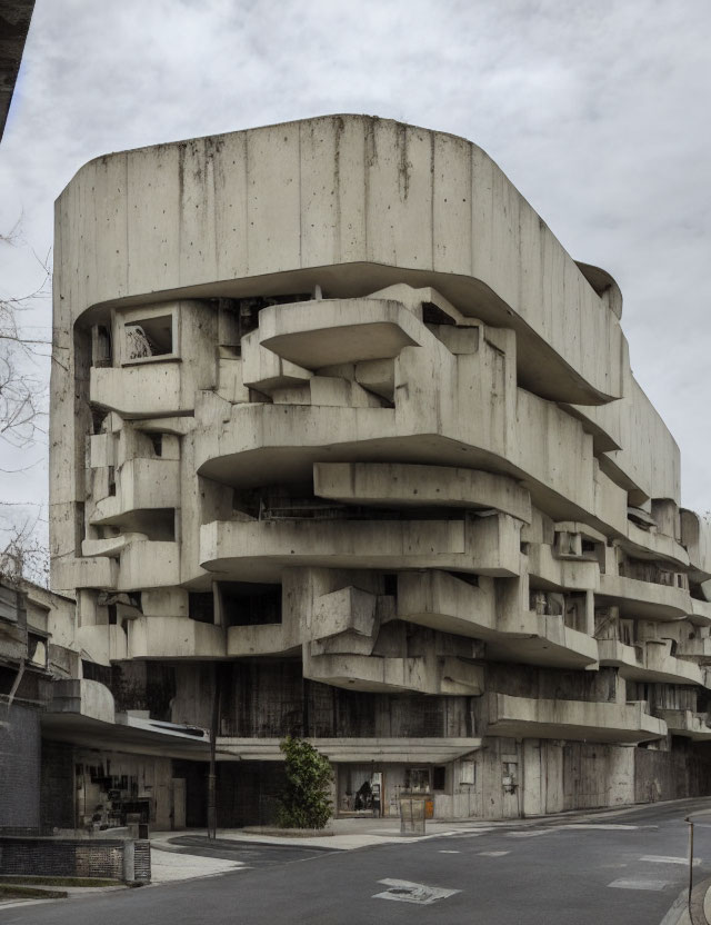 Staggered balconies on brutalist concrete building under overcast skies