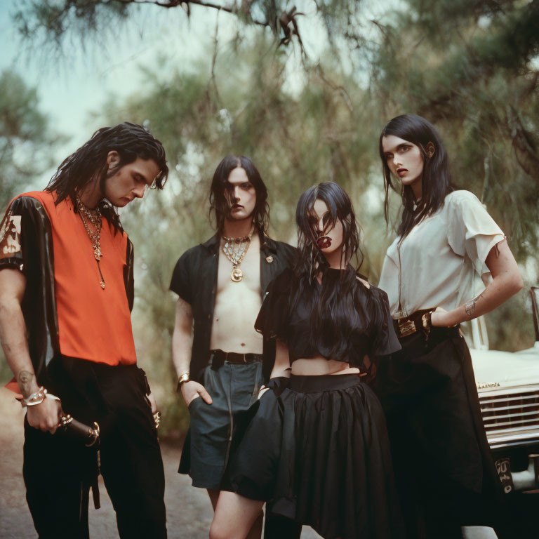 Stylish individuals posing in front of vintage car in wooded area