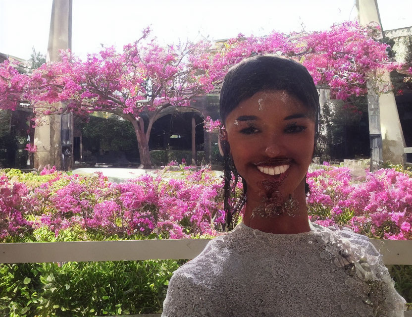 Smiling person in lacey outfit among pink flowering bushes