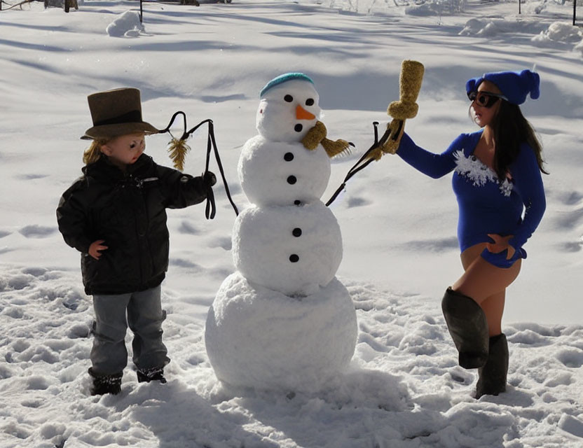 Child and woman by snowman in winter setting