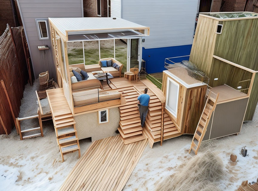 Modern backyard with wooden deck, outdoor furniture, small house, and fences.