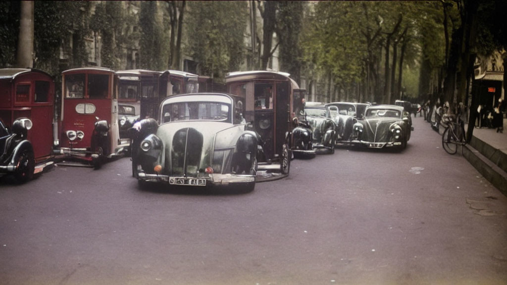 Classic cars and bicycle on tree-lined street from early to mid-20th century