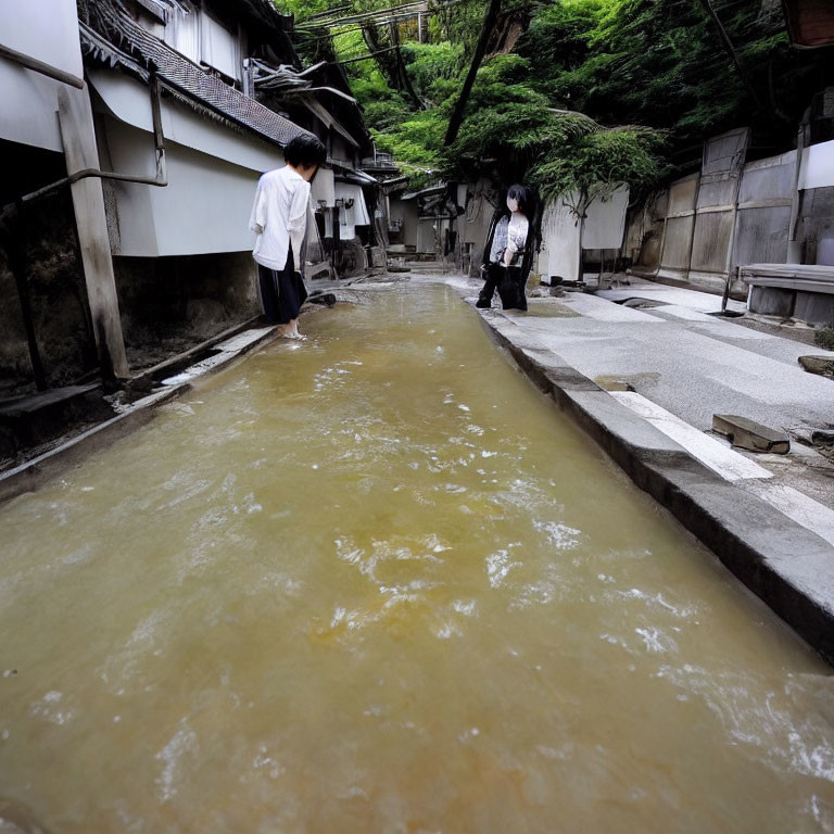 Canal with cloudy water and individuals in traditional stone-lined pathways