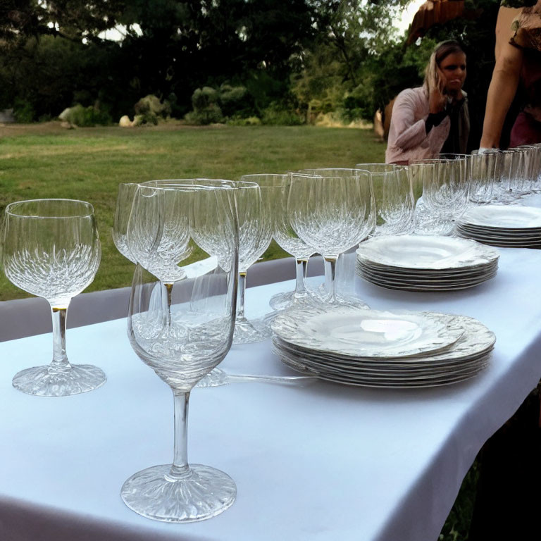 Outdoor Event Table Setting with Wine Glasses and Stacked Plates