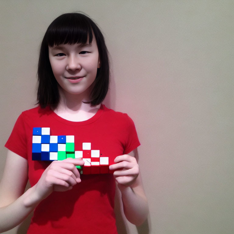 Smiling girl with bob haircut holding Tetris-themed puzzle