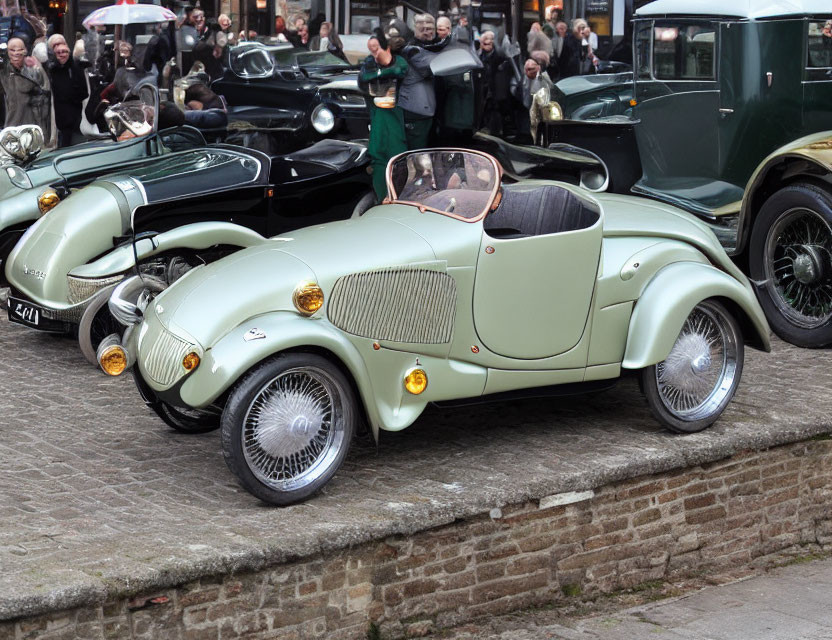 Classic Cream Sports Car Surrounded by Vintage Cars and Attendees