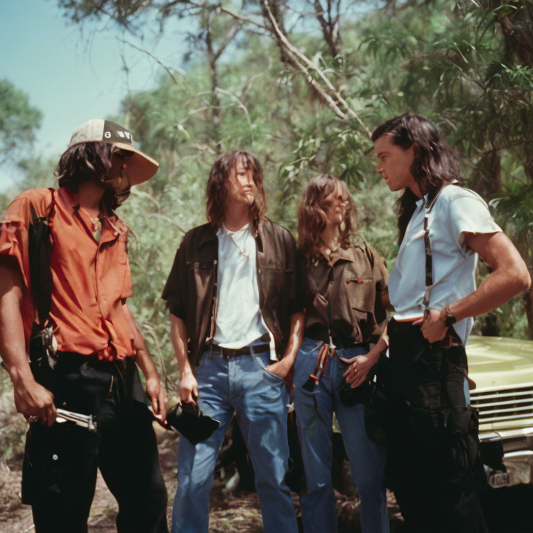 Group of people chatting near car in forest clearing