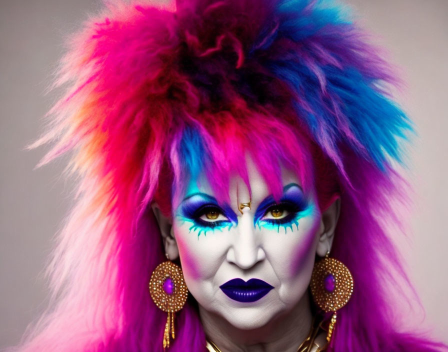 Colorful makeup and vibrant faux-fur headpiece with gold earrings.