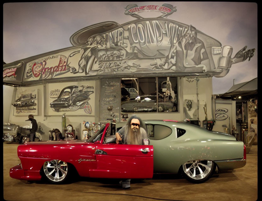 Bearded man in vintage car at custom car show with banners