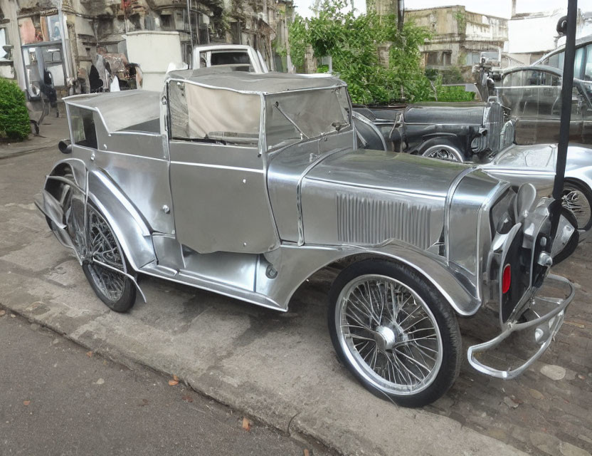 Classic Silver Convertible Car with Spoke Wheels on Outdoor Display