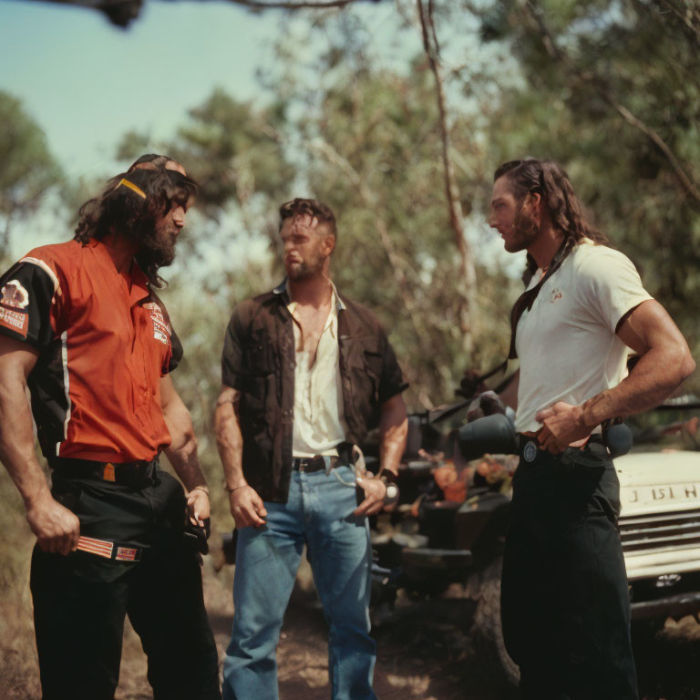 Three Men Talking Outdoors with Motorcycle and Truck in Background