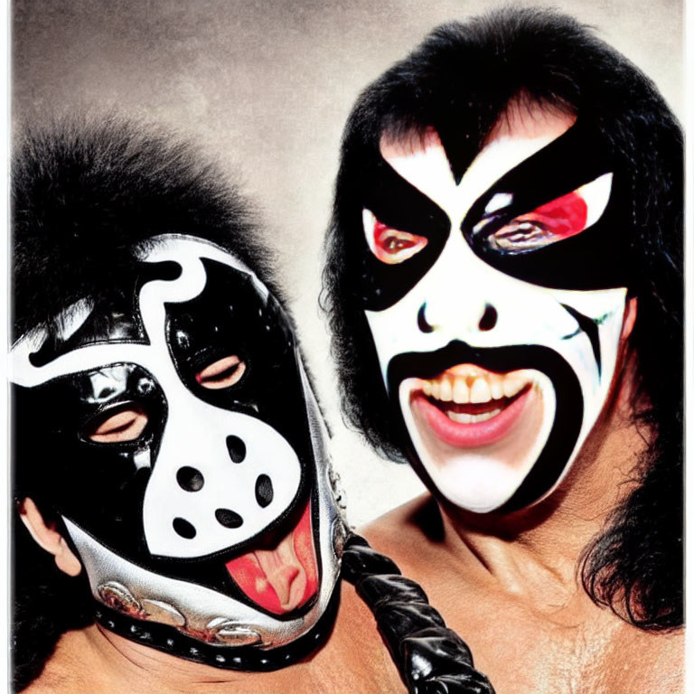 Dramatic black and white face paint duo sticking out tongues