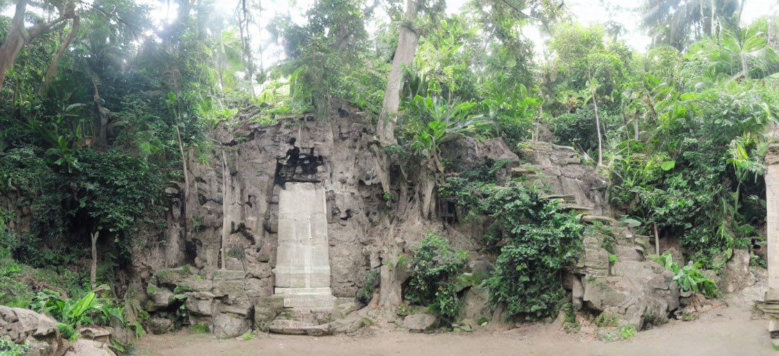 Weathered Stone Monument Surrounded by Tropical Foliage and Path