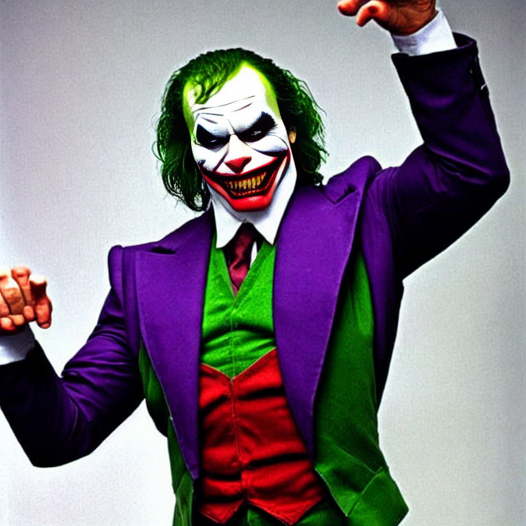 Person in Joker costume with white face paint and green hair striking dramatic pose