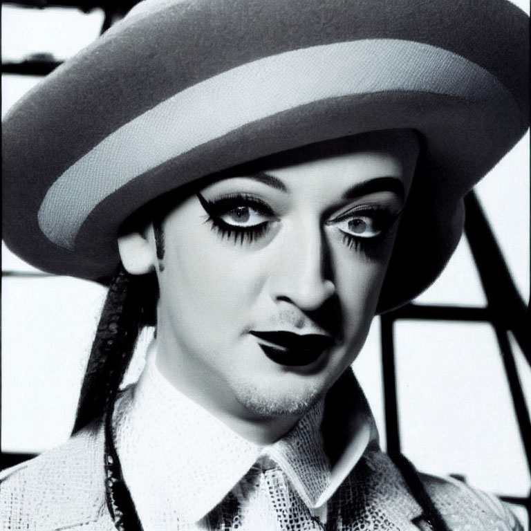 Monochrome portrait of person with dark lipstick and large brimmed hat