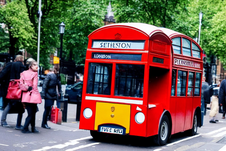 City street scene with red double-decker bus and pedestrians.