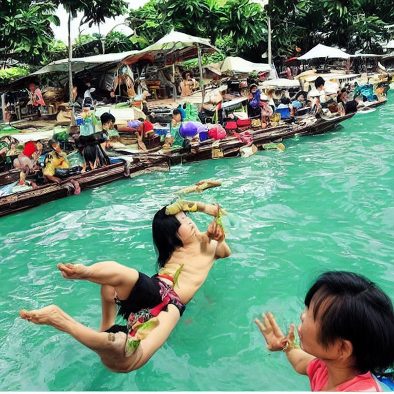 Two people in green water with boats and market stalls in the background.