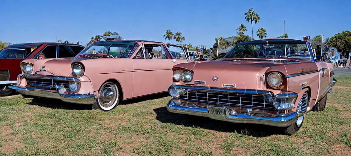 Vintage Pink Cars with Chrome Detailing at Outdoor Car Show