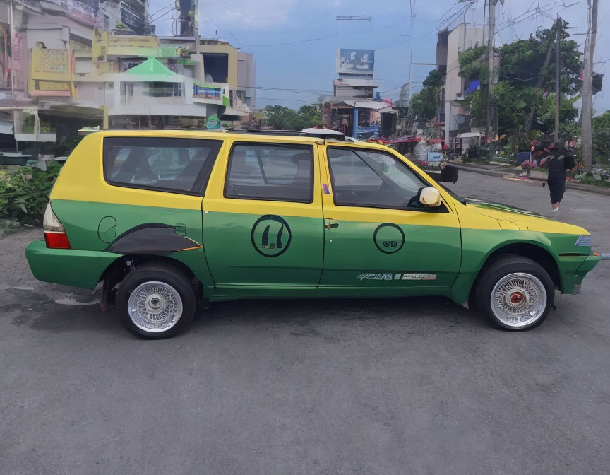 Custom green and yellow car with extra side wheels parked in city street scenery