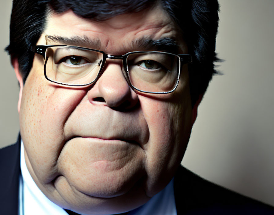 Portrait of a solemn man with prominent cheeks and browline glasses