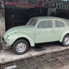 Vibrant lime green Volkswagen Beetle among classic cars in various colors