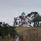 Rocket-shaped House Surrounded by Lush Vegetation and Flying Rocket