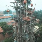 Ancient buildings on towering rock formation with spiral stairs overlooking sea and spires