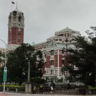 Vertical garden on multi-tiered building with red accents and traditional architecture against hazy sky