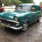 Vintage Green Car with Chrome Detailing in Gravel Lot with Classic Caravans