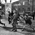 Group of children and adult walking near rundown buildings